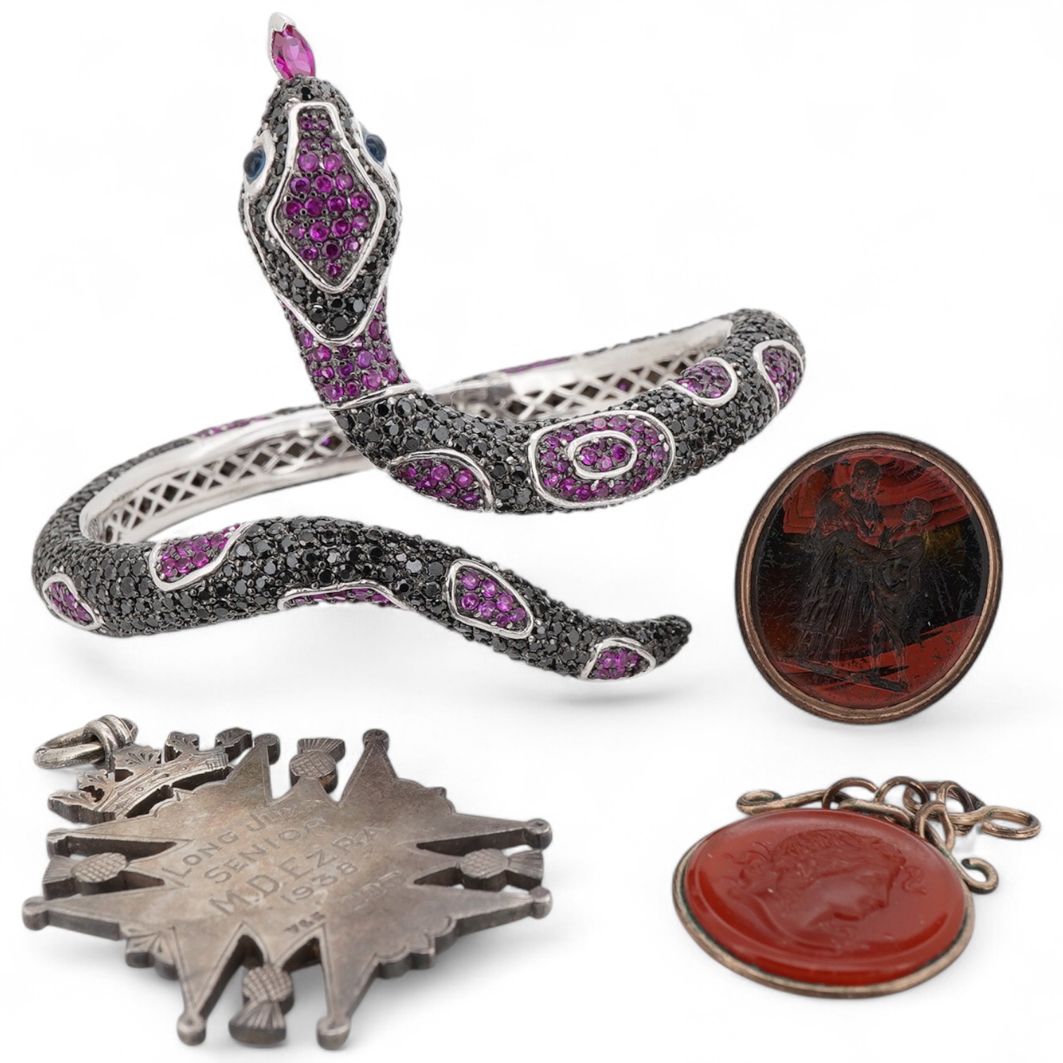 A collection of jewels including a snake bracelet, comprising: a hinged bangle modelled as a snake in silver, pavé-set with circular-cut black sapphires and synthetic rubies, its tongue a marquise-shaped synthetic ruby,